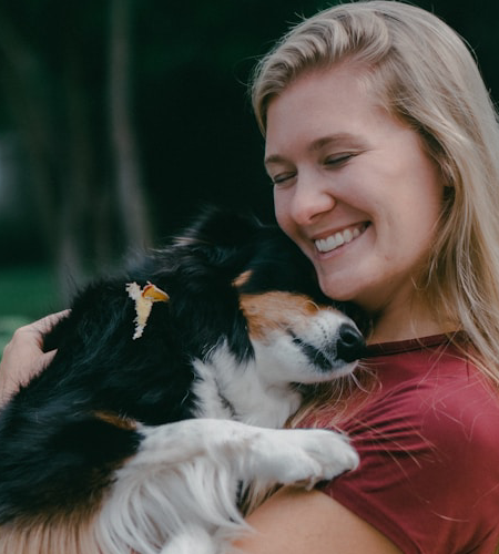 dog snuggled in owner's arms